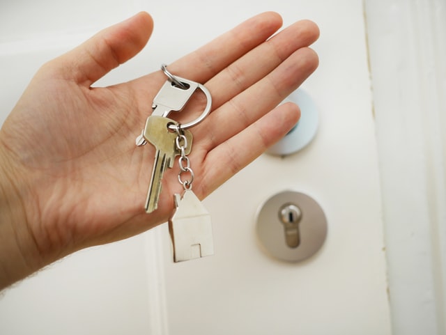 keys held in palm next to door